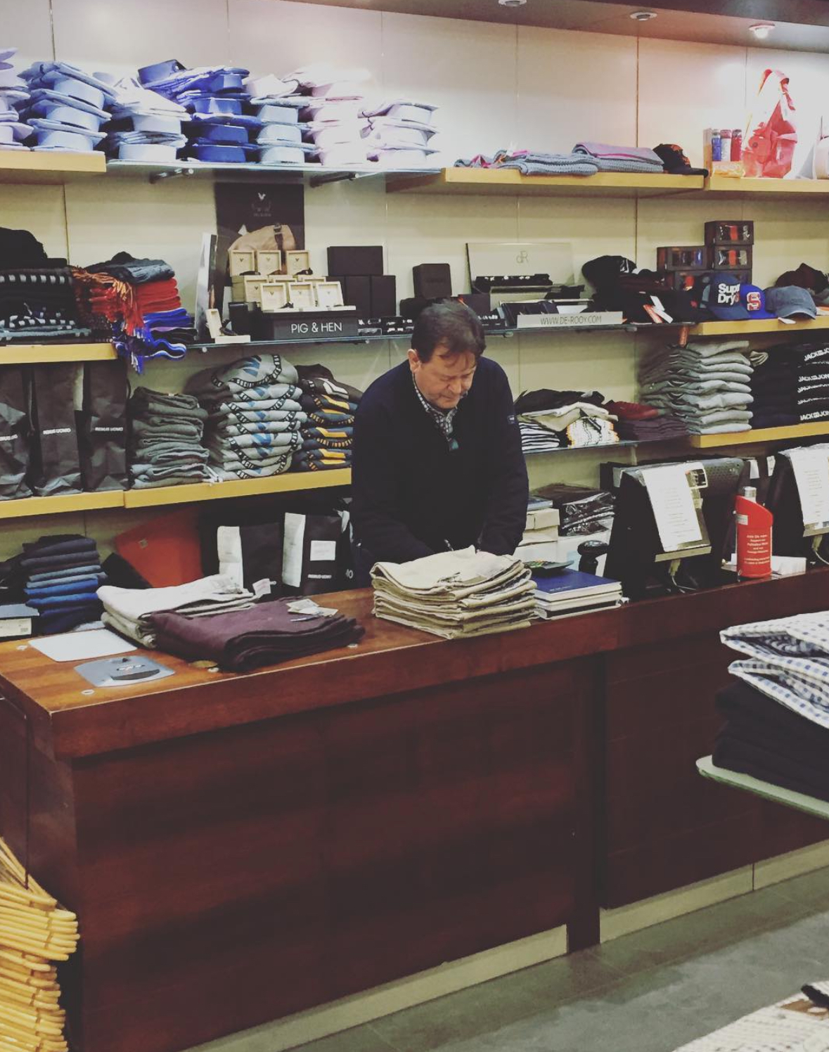 Barry behind the counter folding shirts in the shop